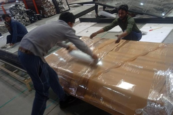 Professional movers packing household items in cardboard boxes